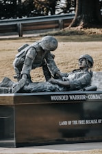 a statue of a man laying on top of a man laying on the ground