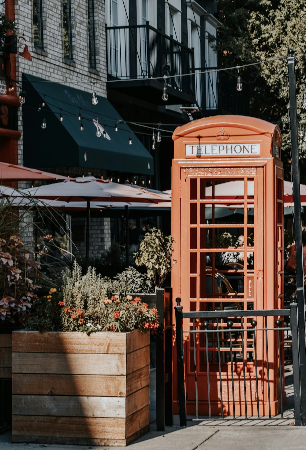 a red phone booth sitting on the side of a road