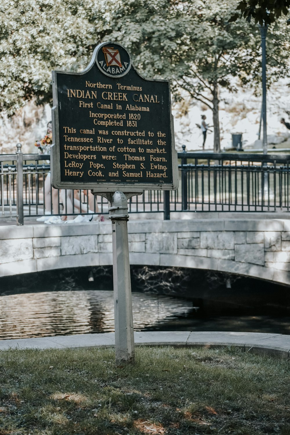 a sign in front of a small pond