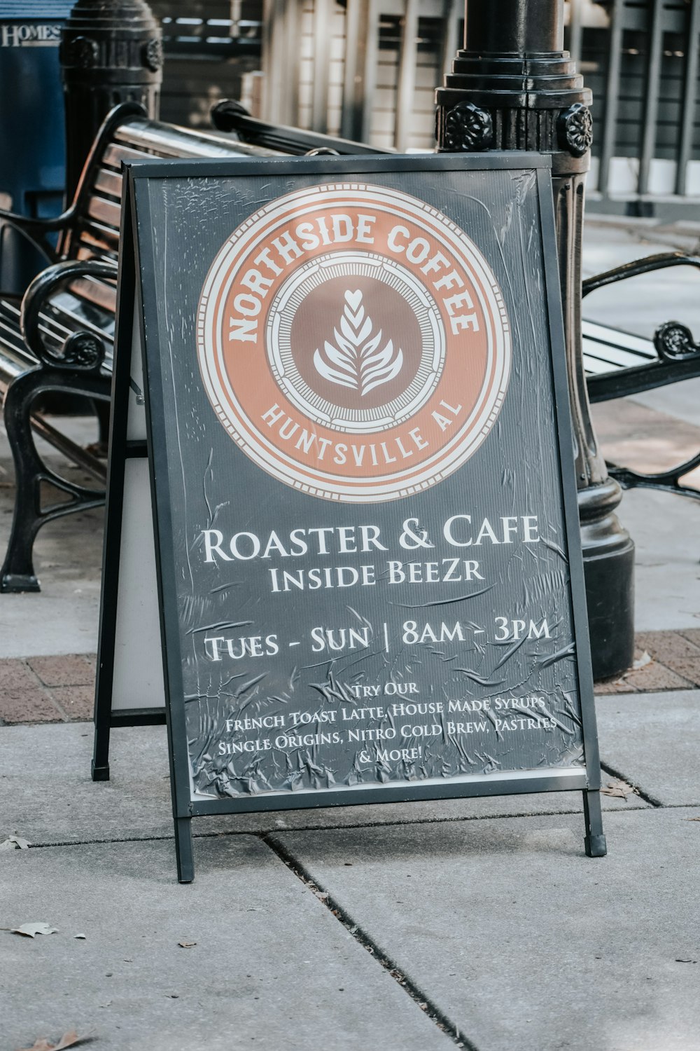 a sign for roaster and cafe on the sidewalk