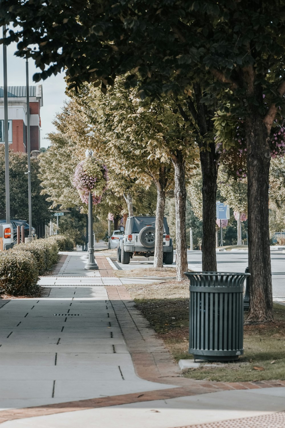 a city street with a trash can on the side of the road