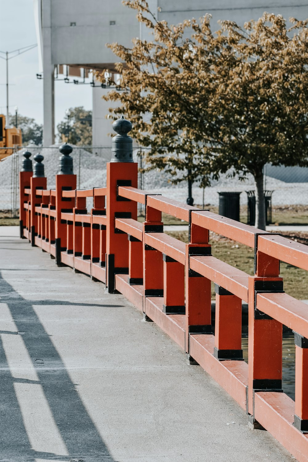 a row of red benches sitting next to a tree