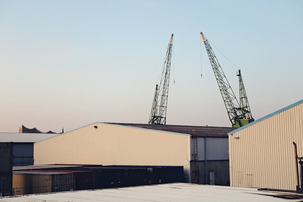 two cranes on top of a building next to a building