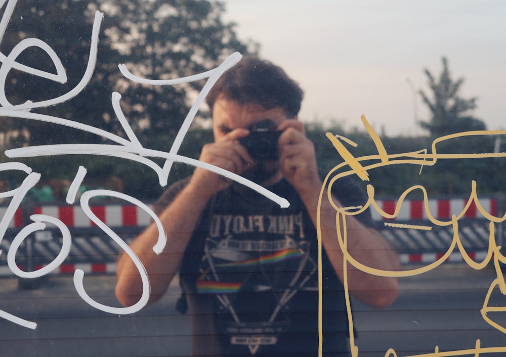 a man taking a picture through a window with a camera