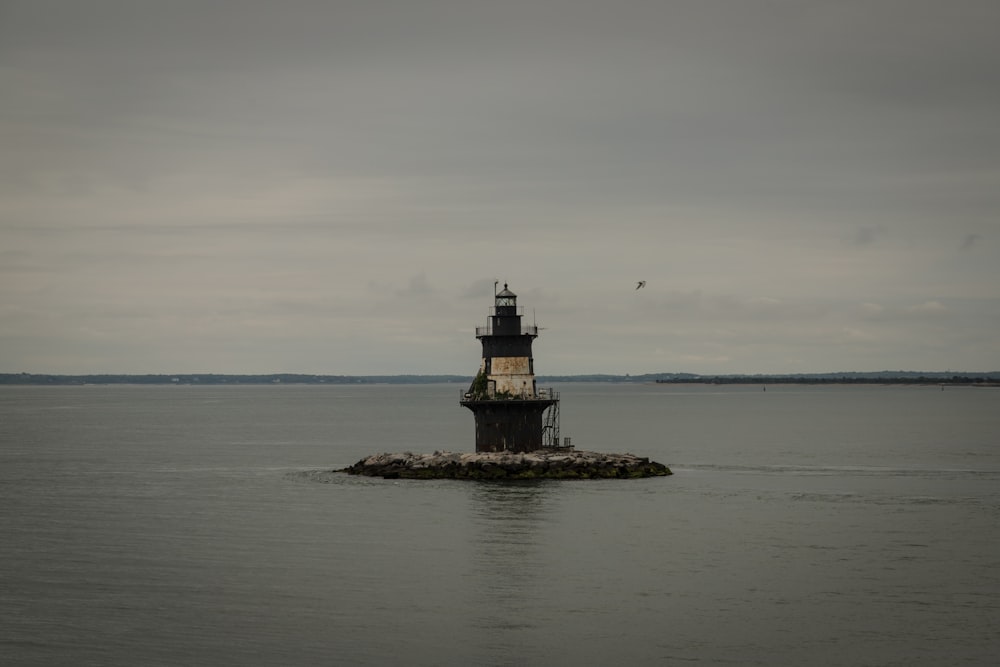 a light house sitting in the middle of a body of water