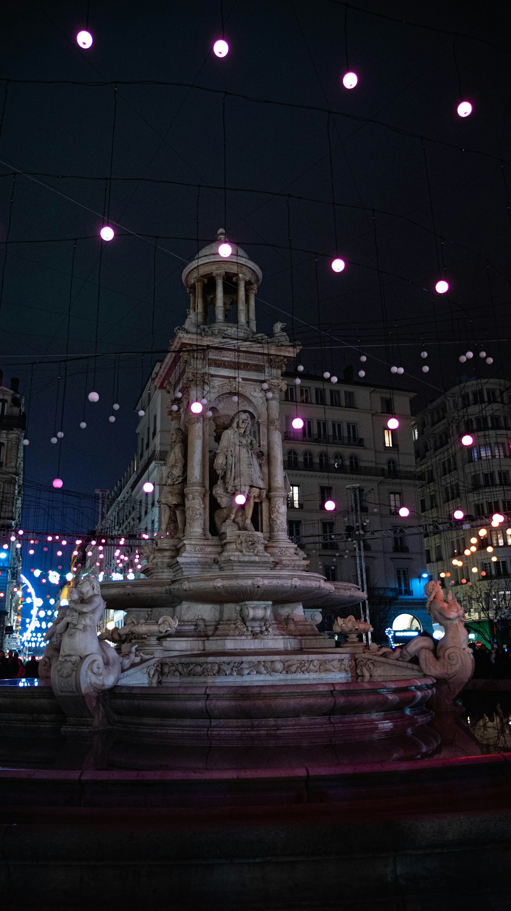 a fountain in the middle of a city at night