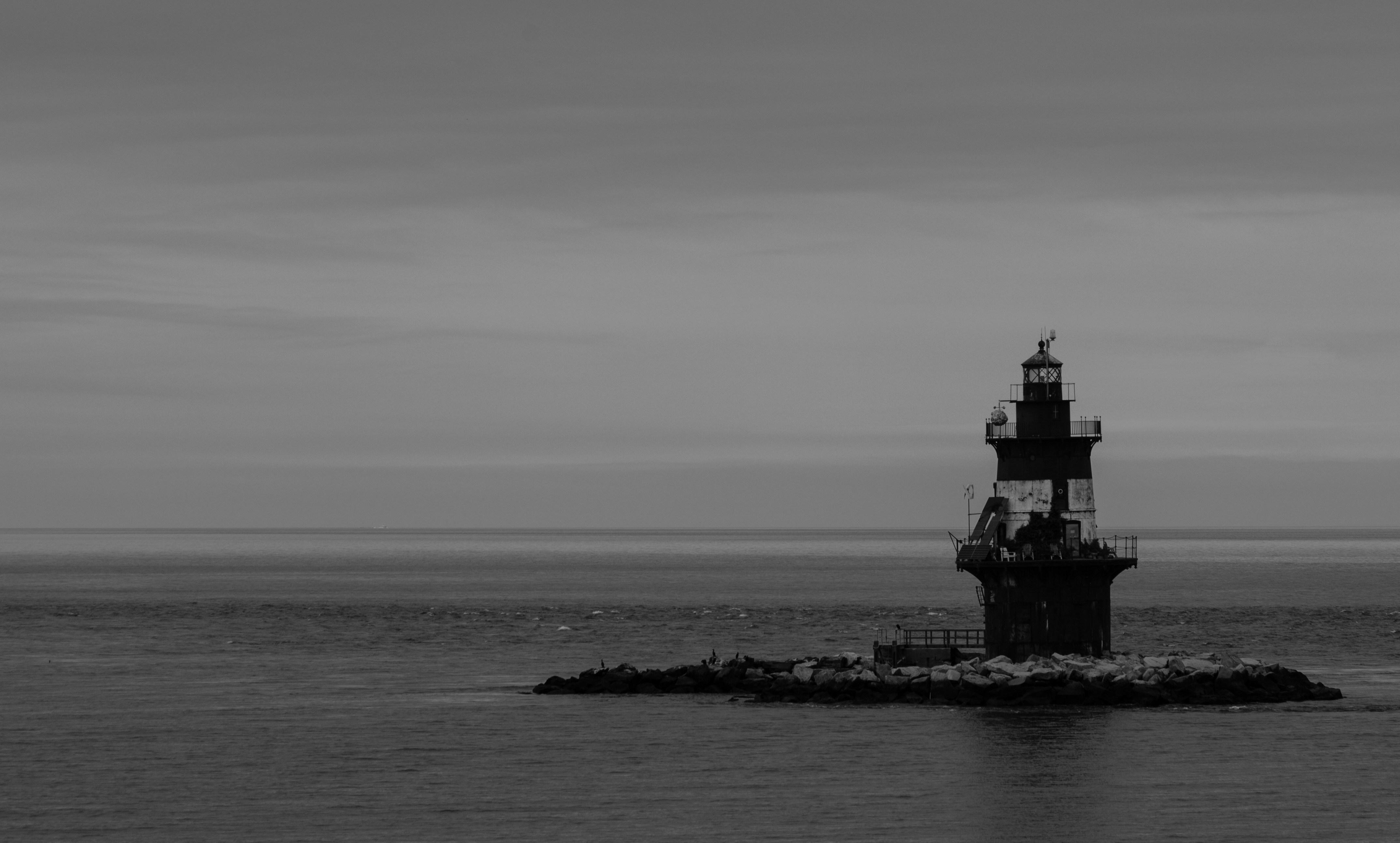 Una foto en blanco y negro de un faro en medio del océano