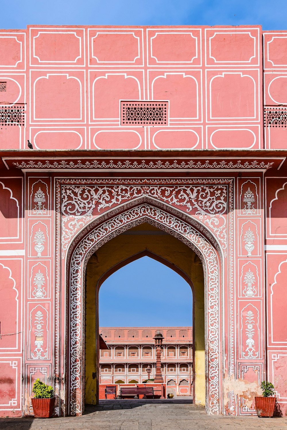 a large pink building with a large archway