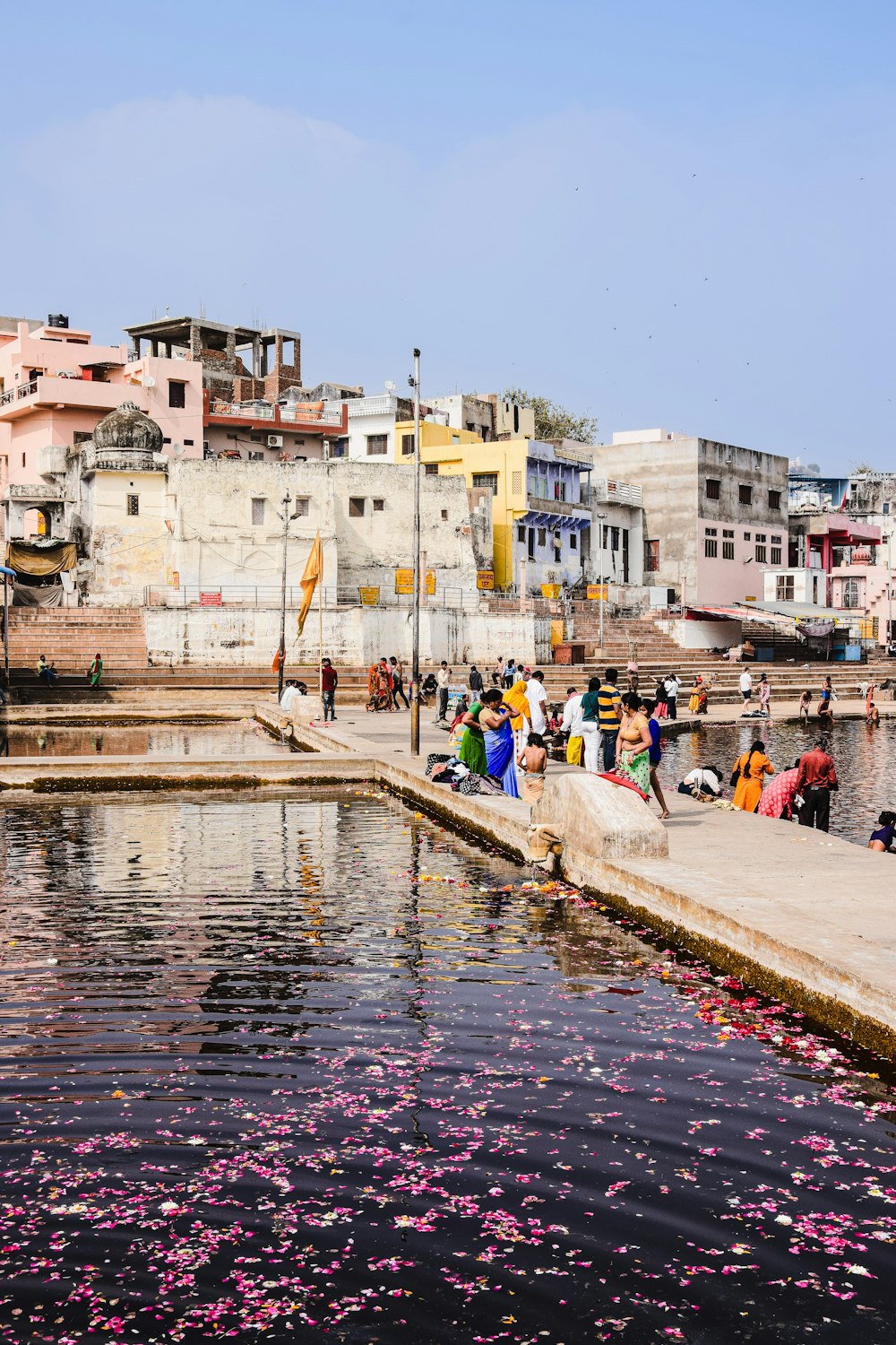 a group of people standing around a body of water