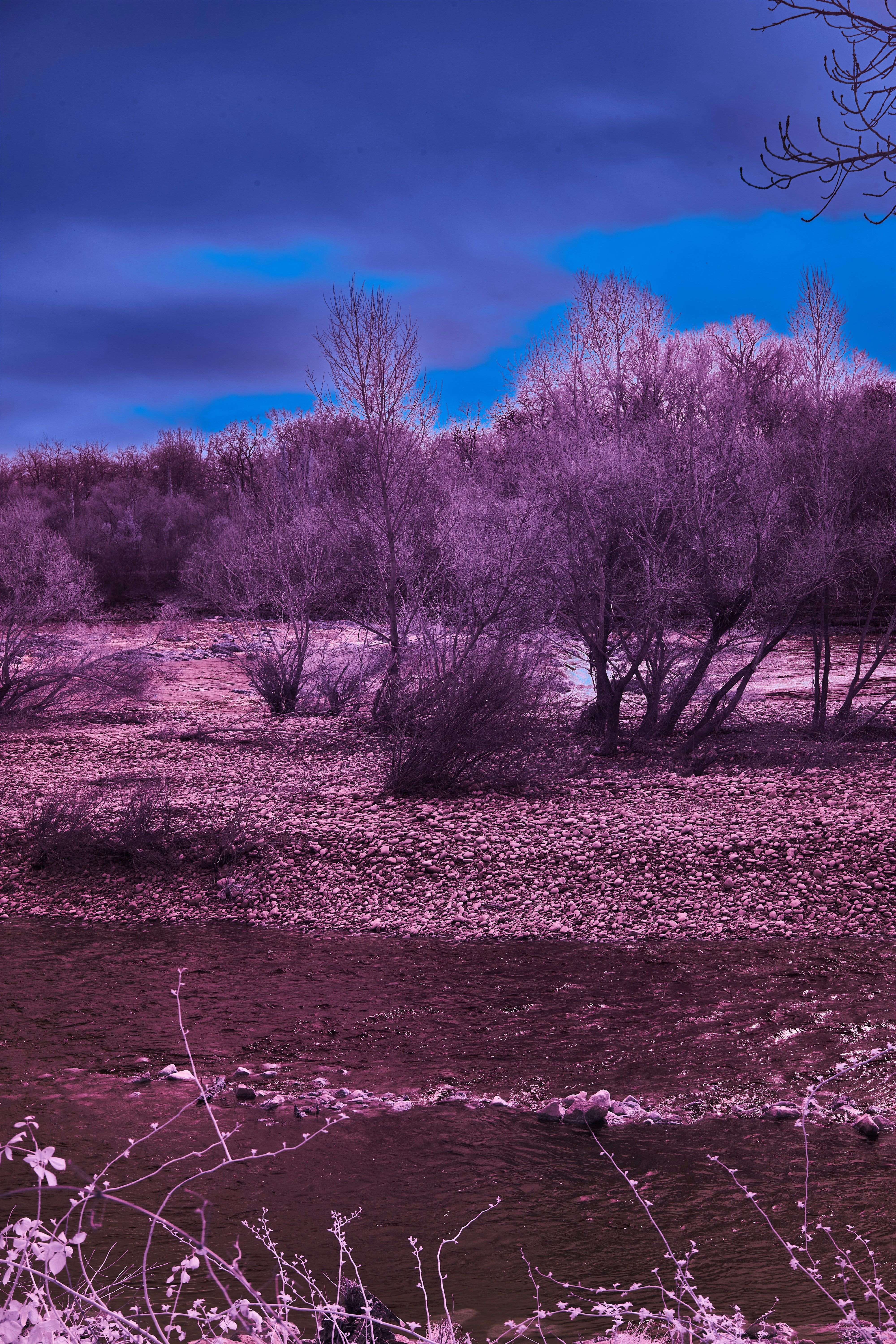 a river running through a dry grass covered field