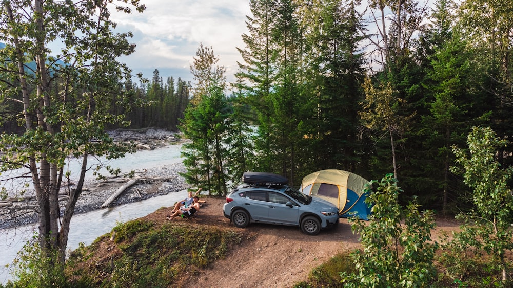 a car parked on a dirt road next to a tent