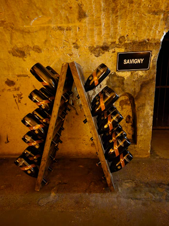 A sommelier pouring a glass of rich Valais wine in front of an elegant wine rack.