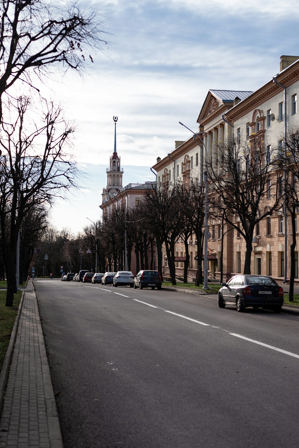 a street lined with parked cars and tall buildings