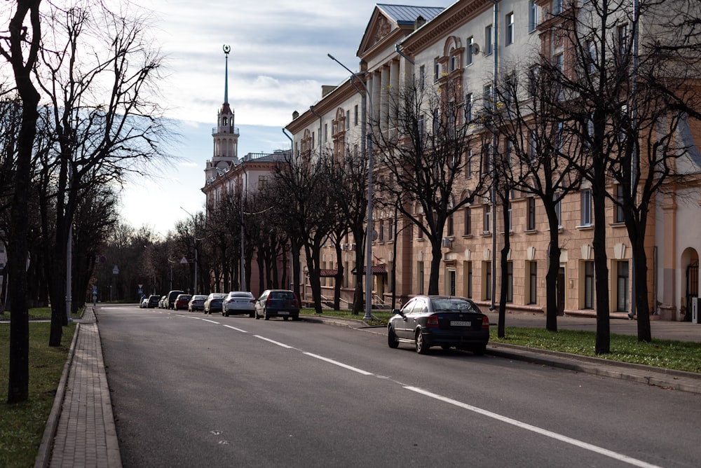 a street lined with parked cars next to tall buildings