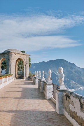 Outdoor terrace of a guesthouse with sculptures and sea view.