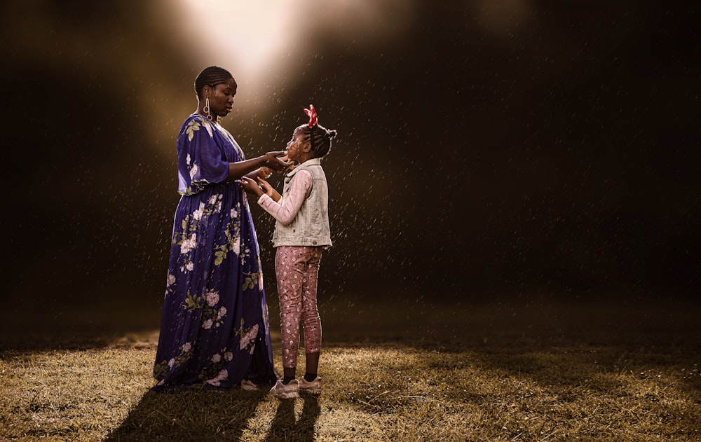 雨の中に立つ女性と子供