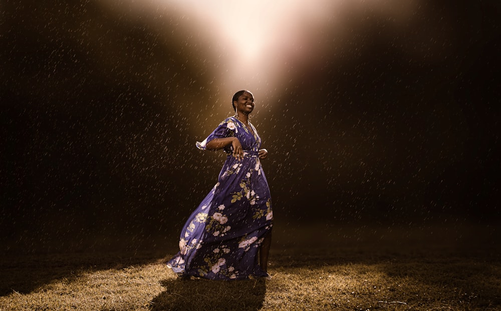 a woman in a purple dress standing in the rain