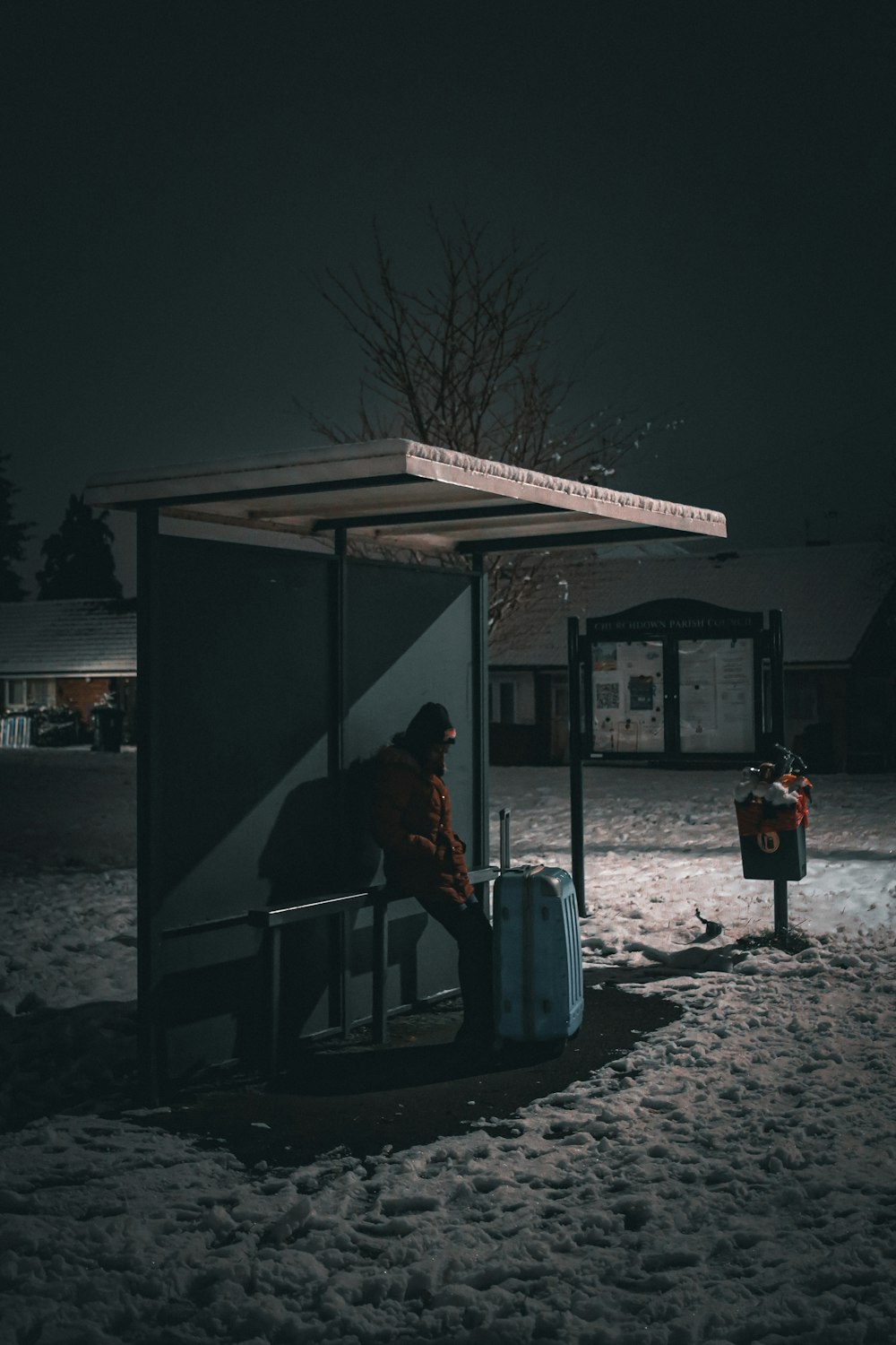 a person sitting on a bench next to a bus stop