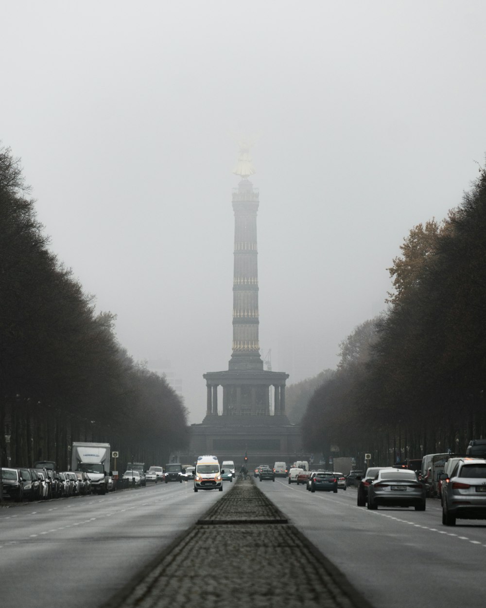 a street with cars and a monument in the background