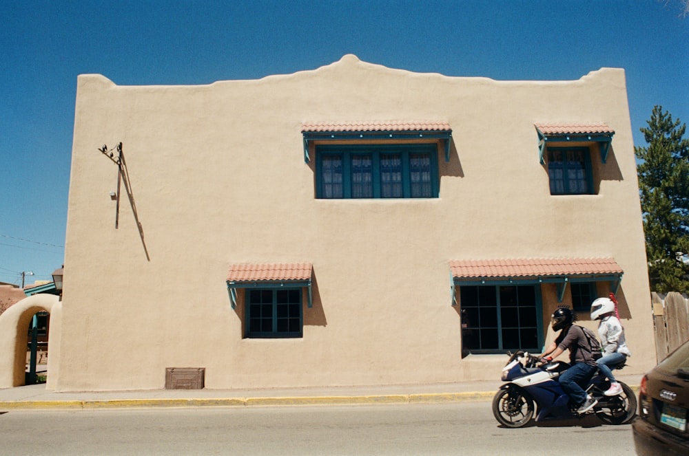 a man riding a motorcycle next to a tall building