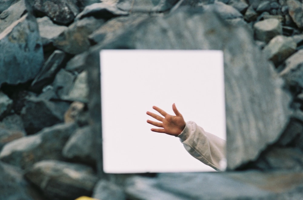 a person reaching out their hand to catch a frisbee