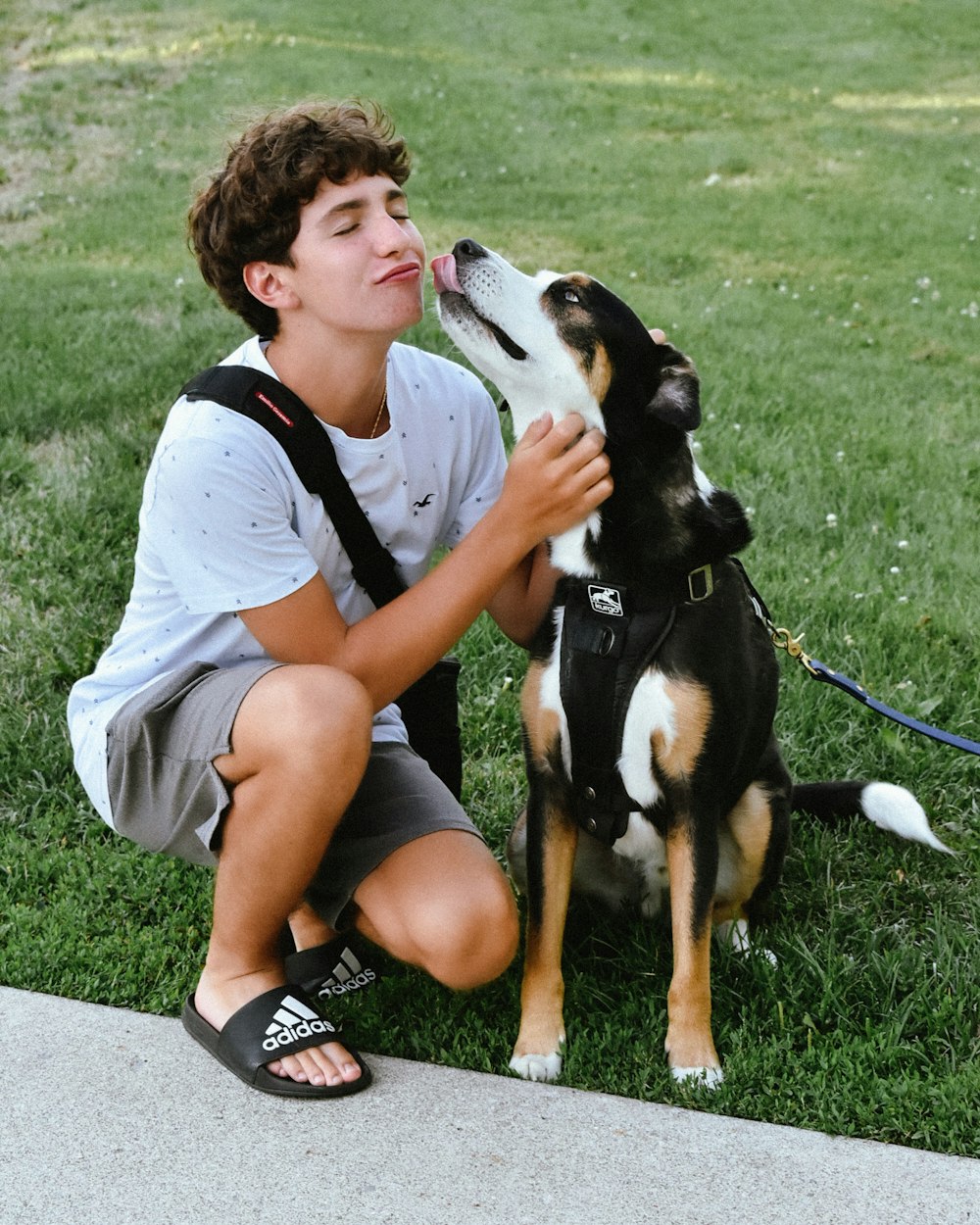 a young man kneeling down next to a dog