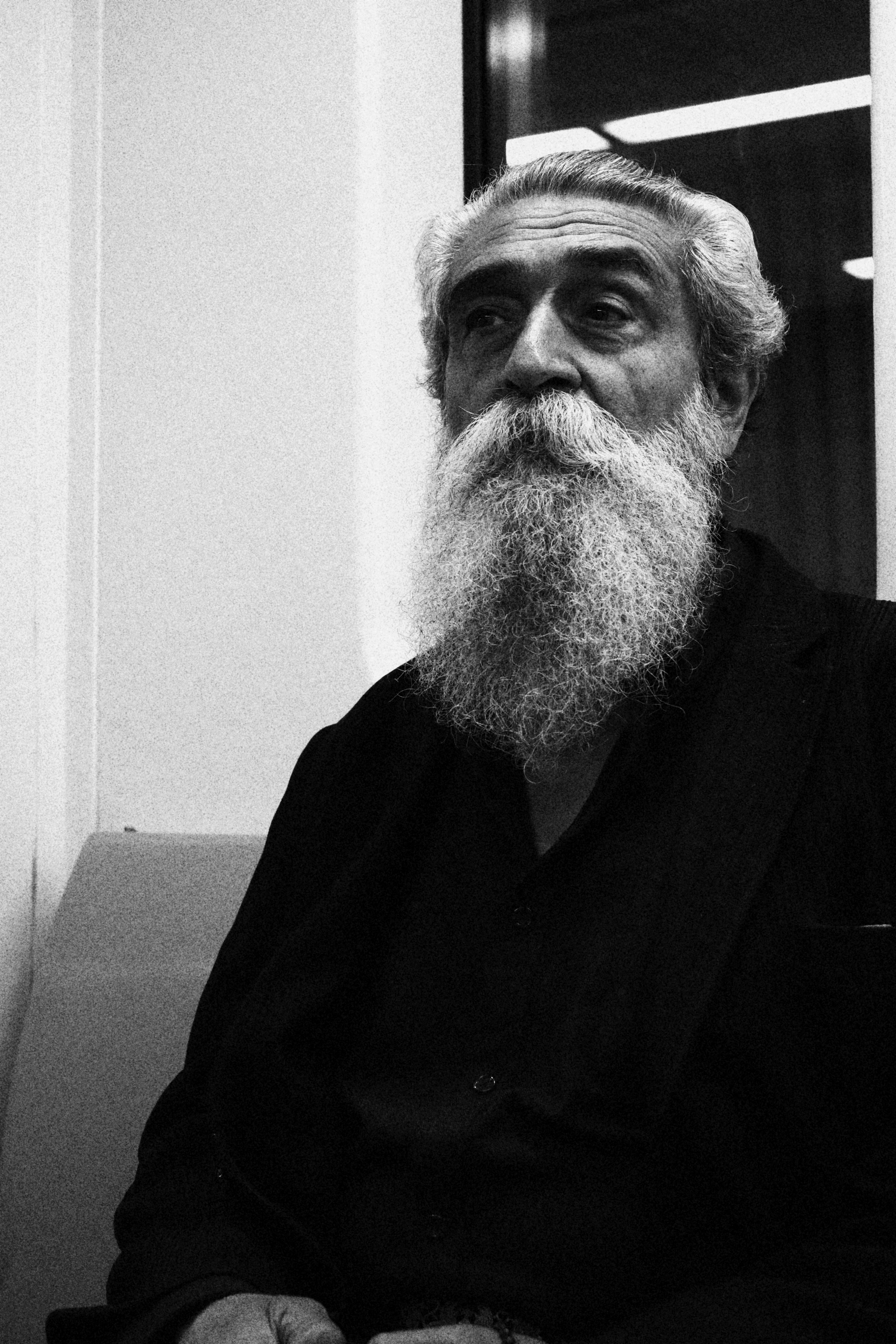 a black and white photo of a man with a long beard