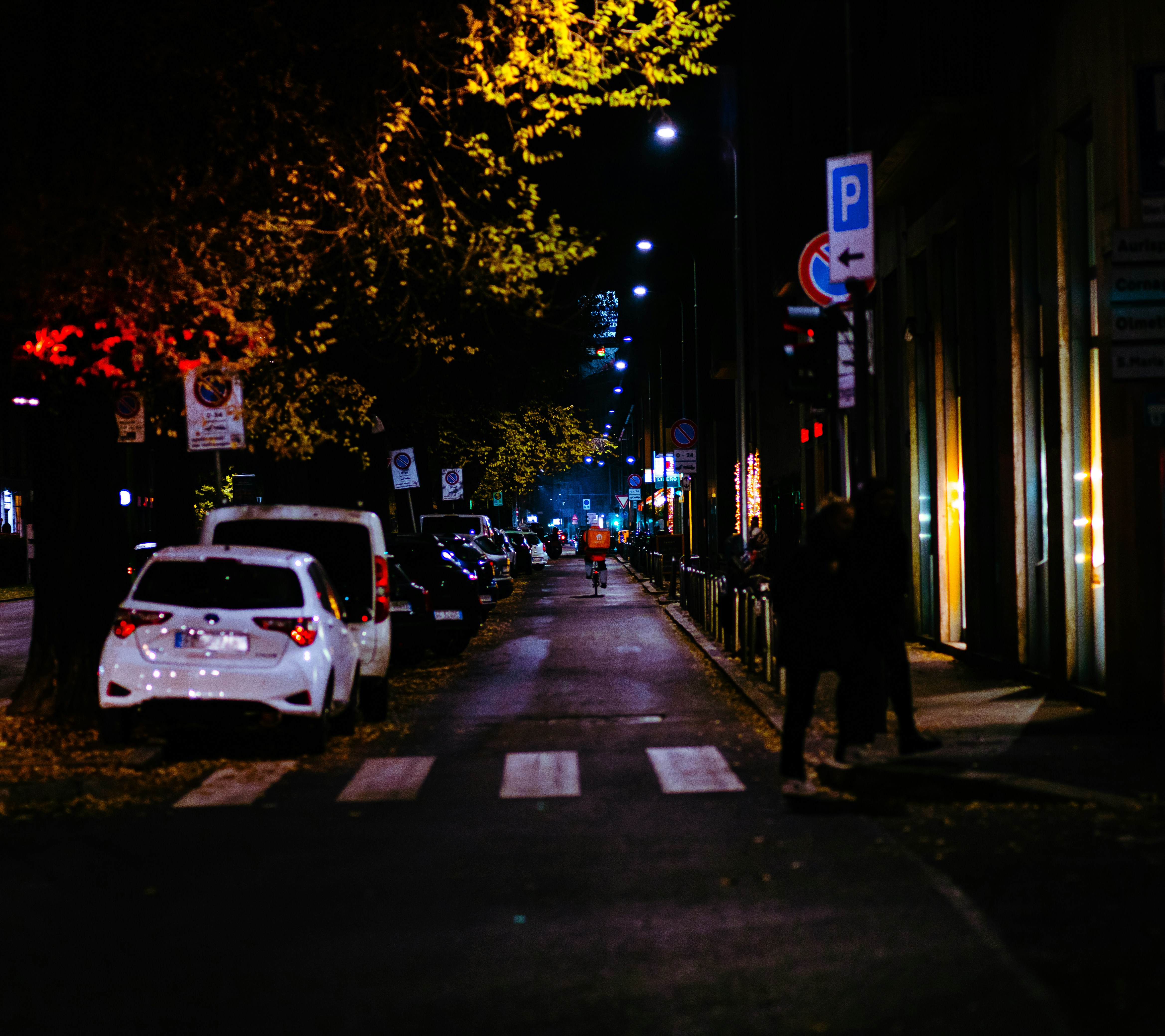 a car parked on the side of a street at night