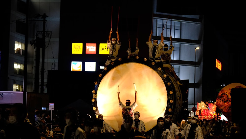a group of people standing around a large drum