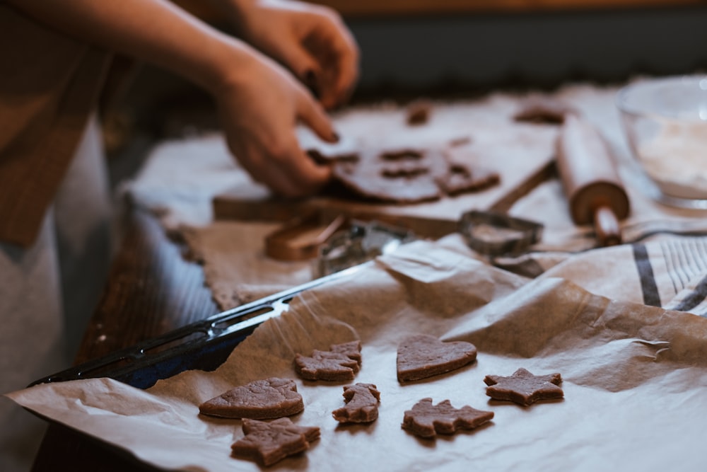 a person cutting up some cookies on a table