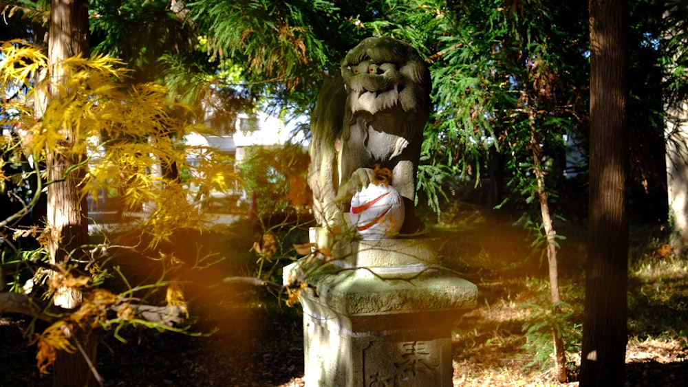 a statue in the middle of a wooded area