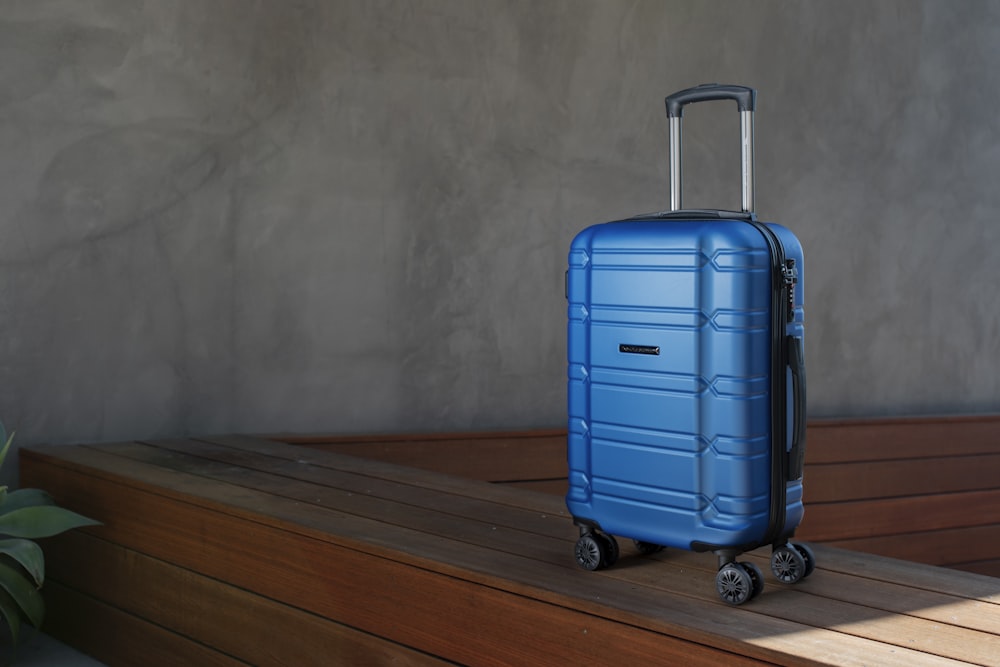 a blue suitcase sitting on top of a wooden floor