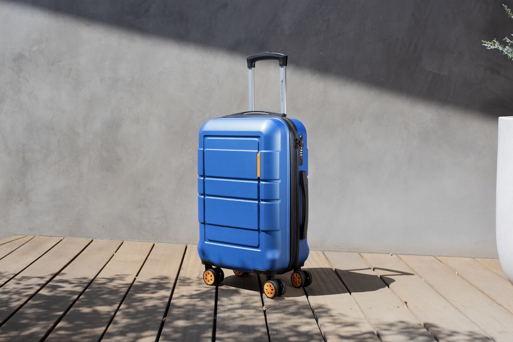 a blue suitcase sitting on top of a wooden floor