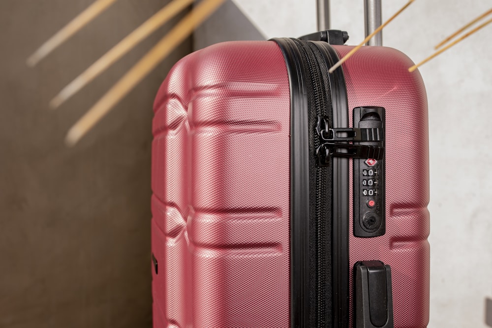 a close up of a red suitcase with a black handle