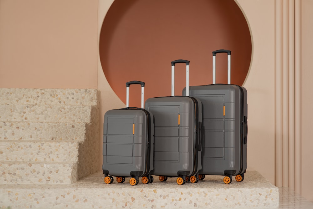 three pieces of luggage sitting on top of a set of stairs