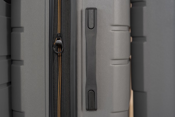 A close-up of a suitcase corner showing durable fabric texture and smooth zipper details under soft natural light.