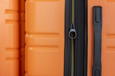 an orange piece of luggage with a black handle