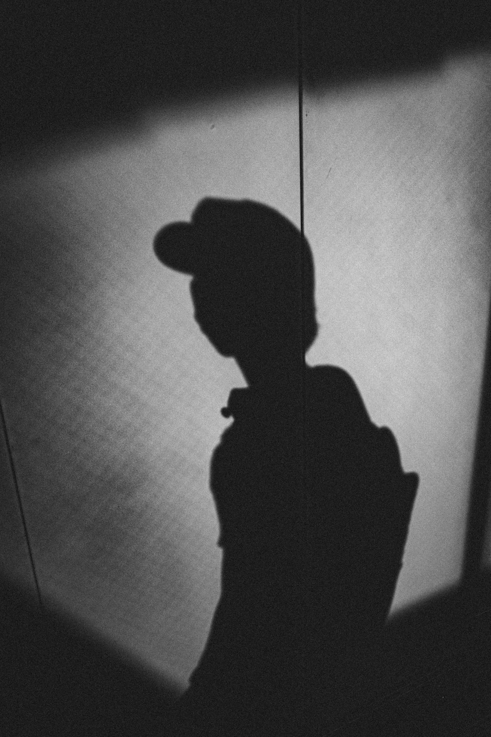 a shadow of a person wearing a hat