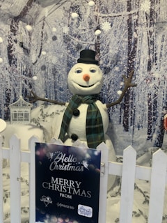 Cute cartoon-style Christmas card showing a cheerful snowman waving hello.