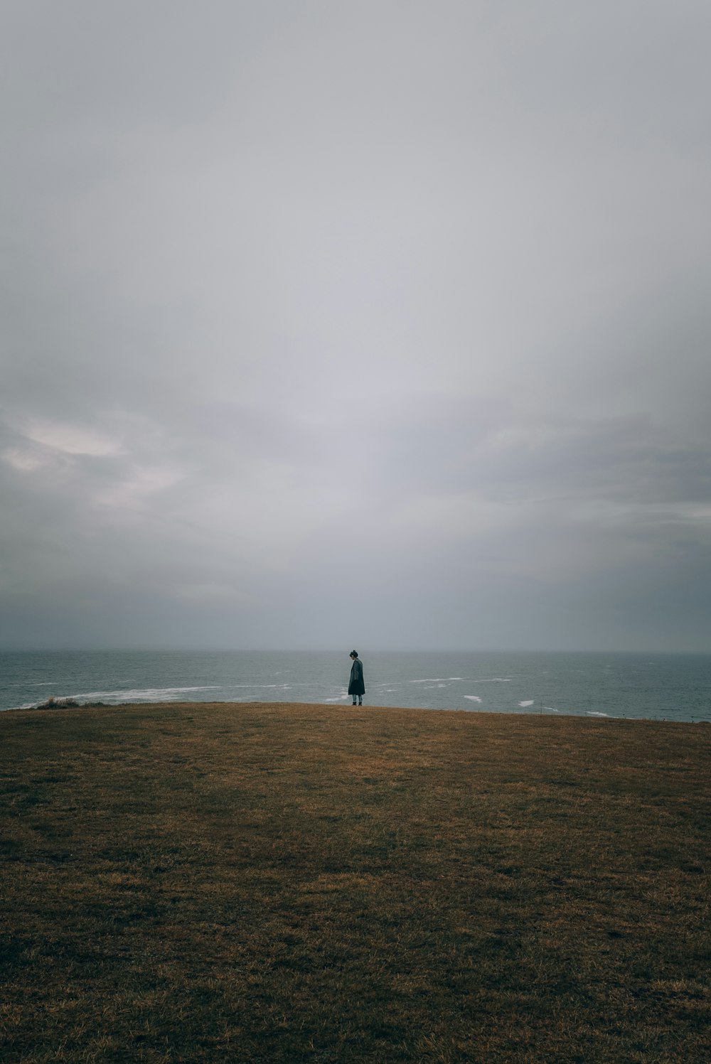 a person standing on top of a grass covered field