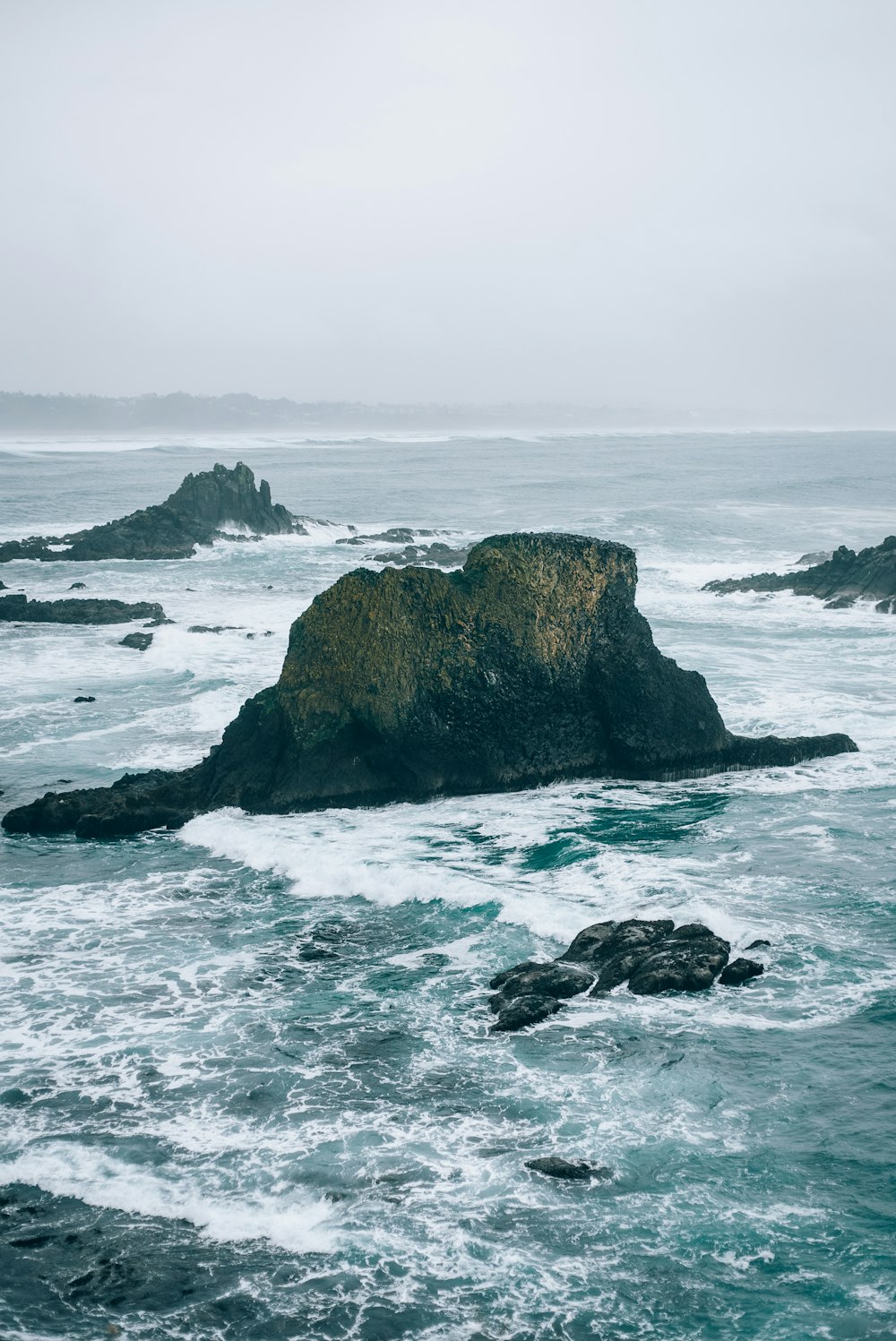 a large rock in the middle of a body of water