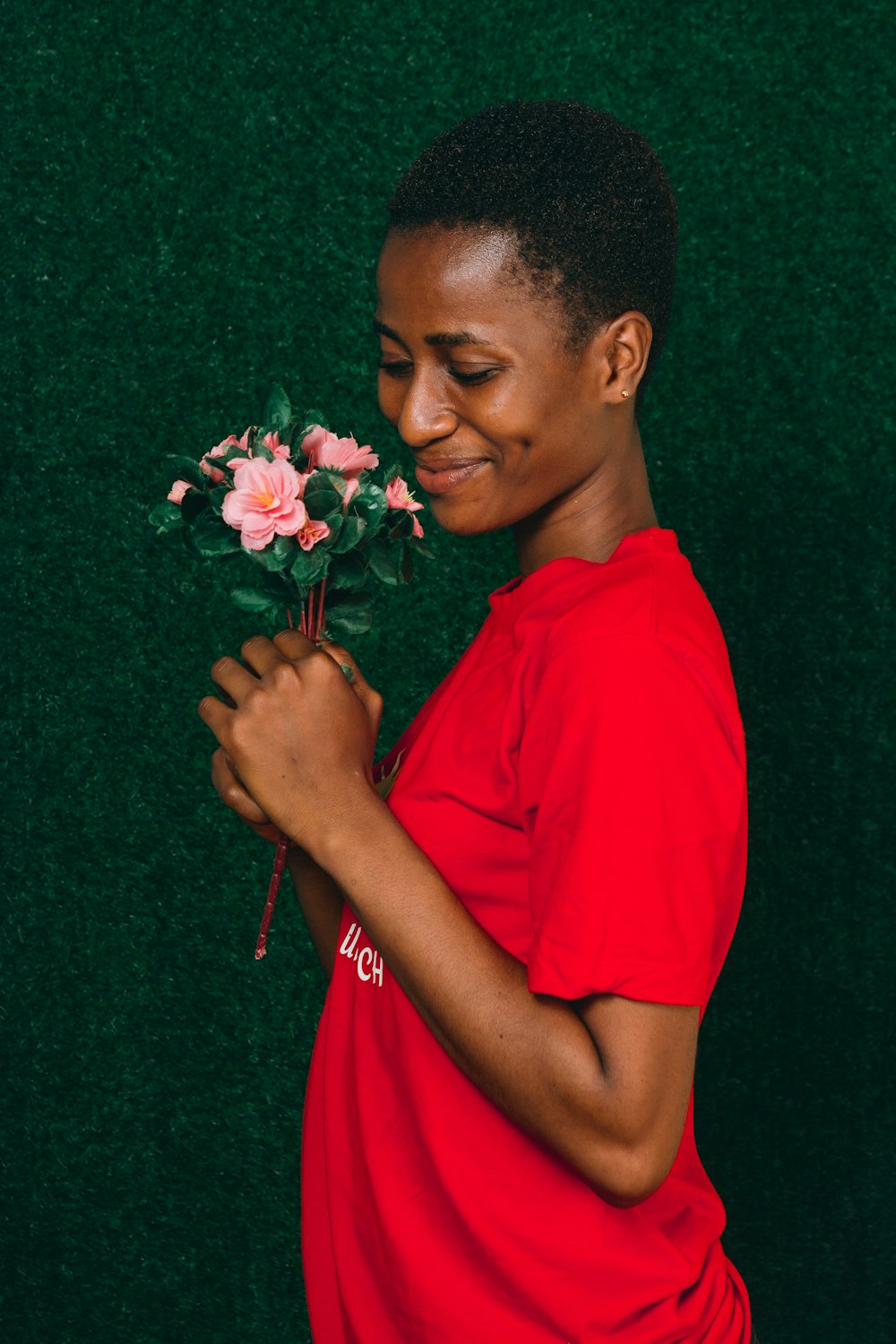 a woman in a red shirt holding a bouquet of flowers