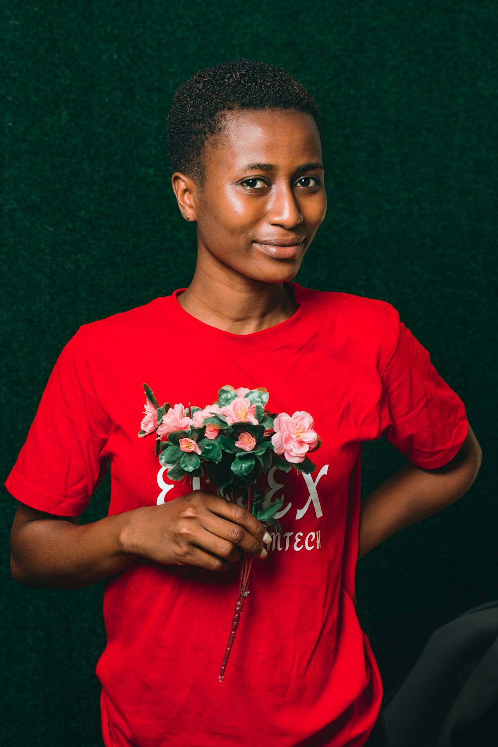 a woman in a red shirt holding a bunch of flowers