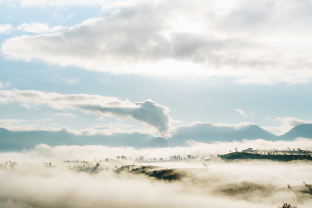 a foggy valley with a mountain in the distance