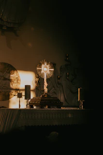 Softly lit altar with golden candles and a shimmering chalice during evening worship