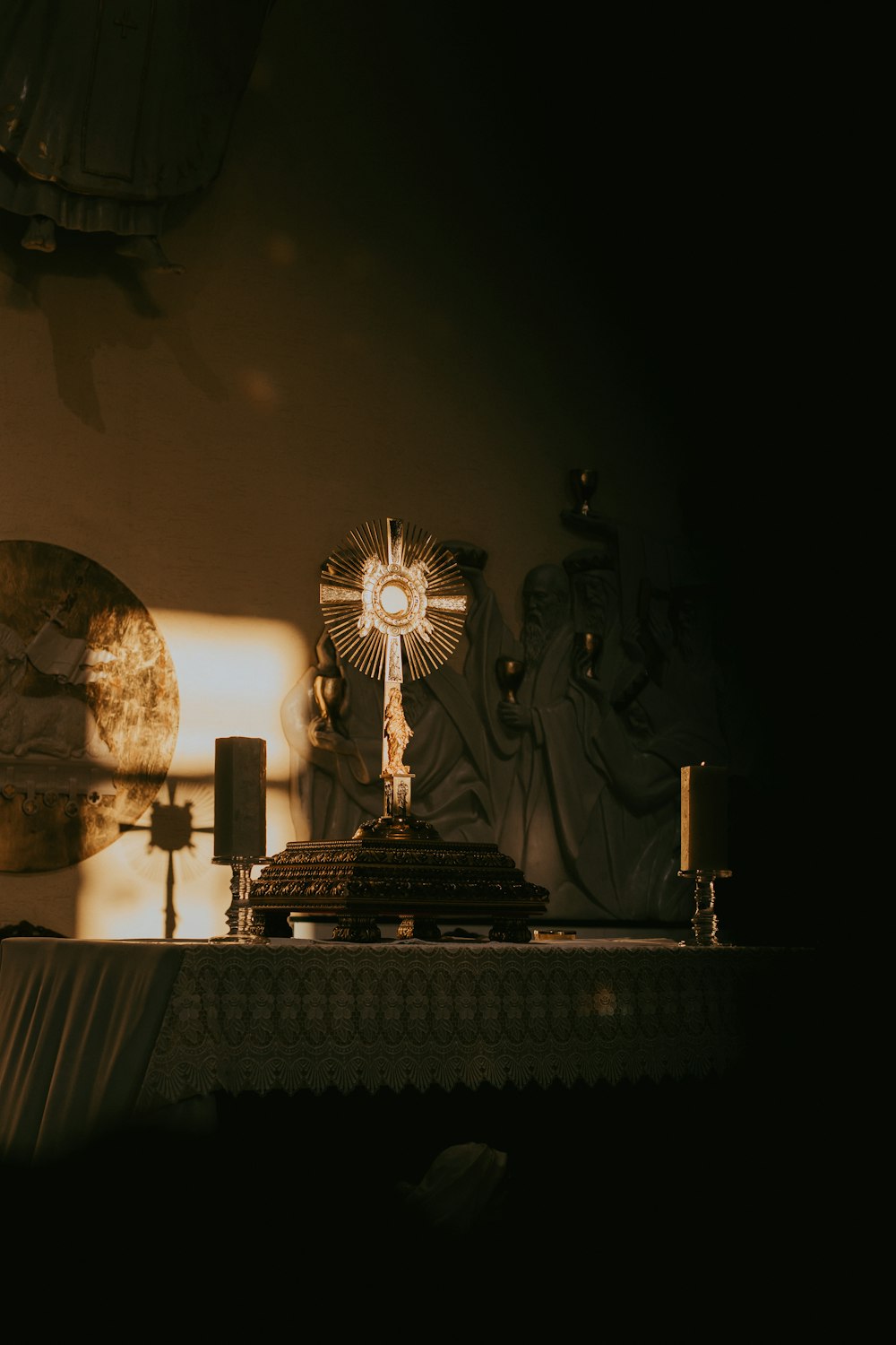 a cross on top of a table next to a lamp