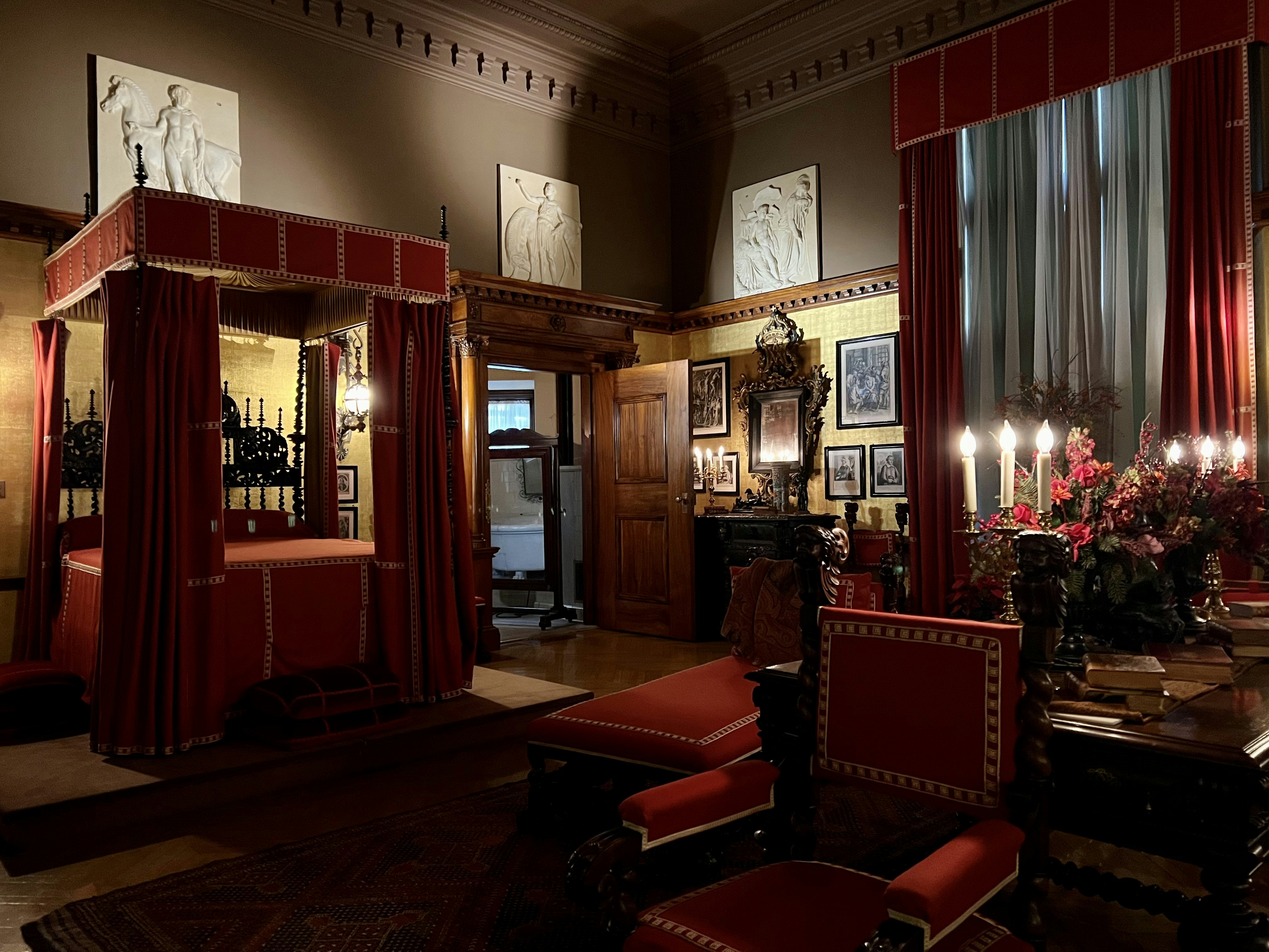 a room with red curtains and a table with chairs