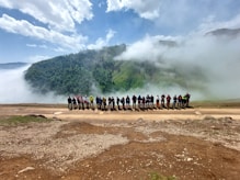 a group of people standing in front of a mountain