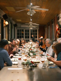 a group of people sitting at a long table