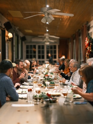 a group of people sitting at a long table